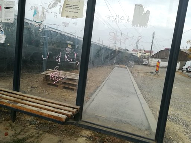 Trotuar construit în spatele unei stații de autobuz până într-un gard