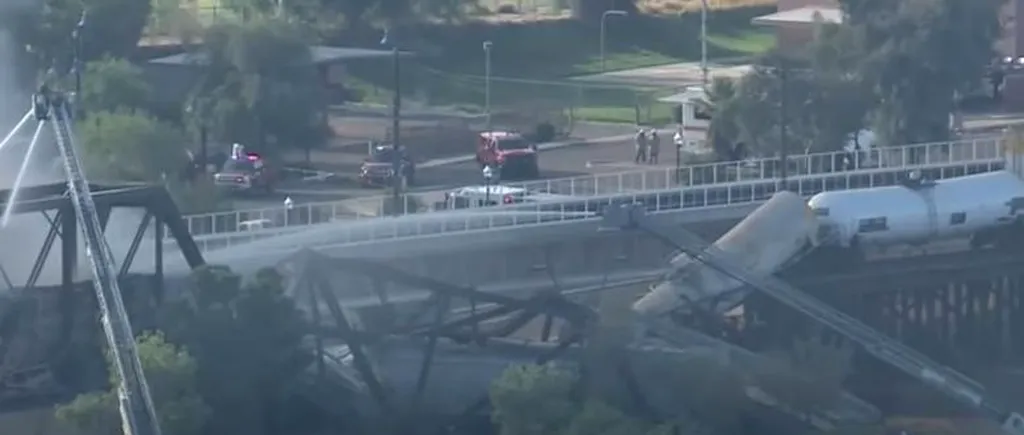 Un pod din SUA s-a prăbuşit parţial, după un accident feroviar. Mai multe vagoane cisternă au deraiat și au luat foc (VIDEO)