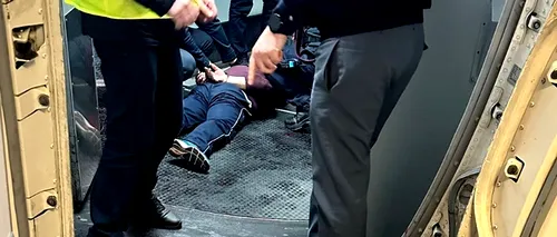 Momentul în care bărbatul care s-a automutilat a fost imobilizat. Imagini din „Avionul Groazei”
