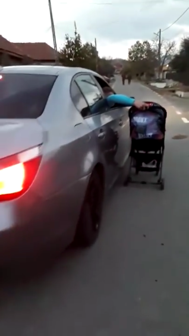 Tatăl unui BEBELUȘ, filmat când PLIMBĂ copilul în cărucior, pe lângă mașina pe care o conduce