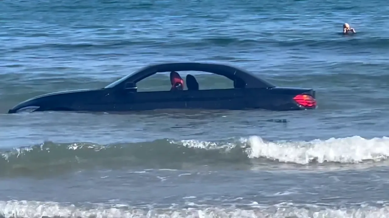 VIDEO | Un BMW a fost luat de valuri și purtat în larg, după ce șoferul l-a lăsat pe plajă. „Nu poți parca acolo, amice”