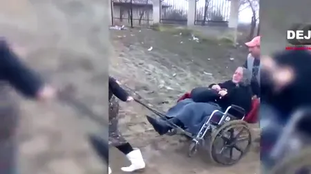 Imagini revoltătoare: mai mulți săteni se chinuie să tragă prin mocirlă o bătrână bolnavă, aflată în scaun cu rotile
