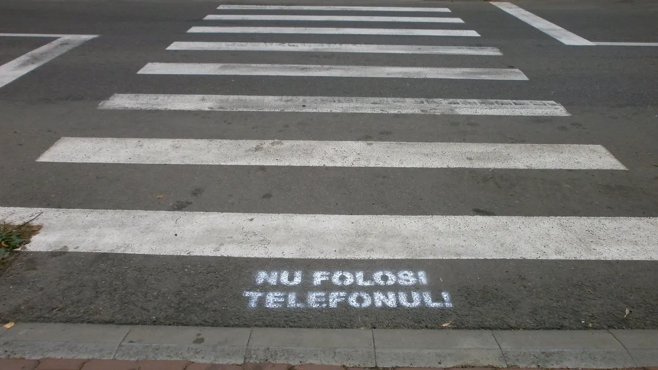 SCOATE CĂȘTILE! Nu folosi telefonul! Elevii din Suceava, întâmpinați la trecerile de pietoni cu MESAJE PE ASFALT
