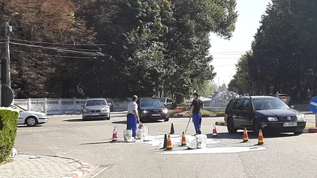 Doi Dorei în acțiune: Angajații unei primării au vărsat vopsea pe stradă și o strâng cu lopeți - VIDEO