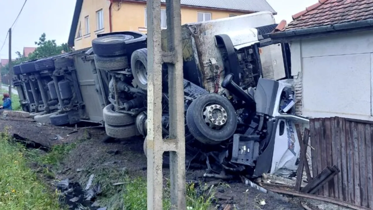 ACCIDENT cumplit pe DN 12/E578. Șoferul unui camion a scăpat „mastodontul” de sub control și s-a răsturnat peste o casă din Harghita