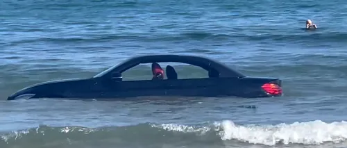 VIDEO | Un BMW a fost luat de valuri și purtat în larg, după ce șoferul l-a lăsat pe plajă. „Nu poți parca acolo, amice”