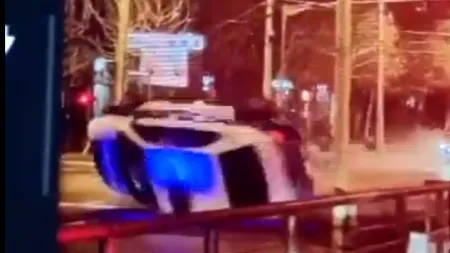 Momentul în care e lovită și răsturnată o mașină de poliție aflată în misiune, în București. O polițistă a fost rănită - VIDEO