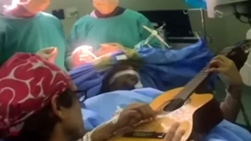 Un bărbat cântă LA CHITARĂ în timp ce este operat PE CREIER. MOTIVUL pentru care i-au recomandat medicii să facă asta