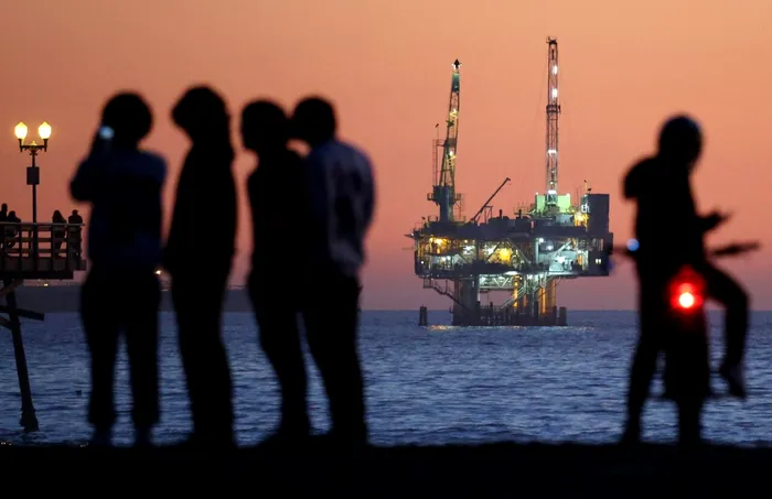 Oamenii se adună pe o plajă din California pentru a admira închiderea platformei petroliere Esther de la distanță. Pe 5 ianuarie 2025, Joe Biden a interzis permanent alte noi foraje pe coasta de est a SUA. 