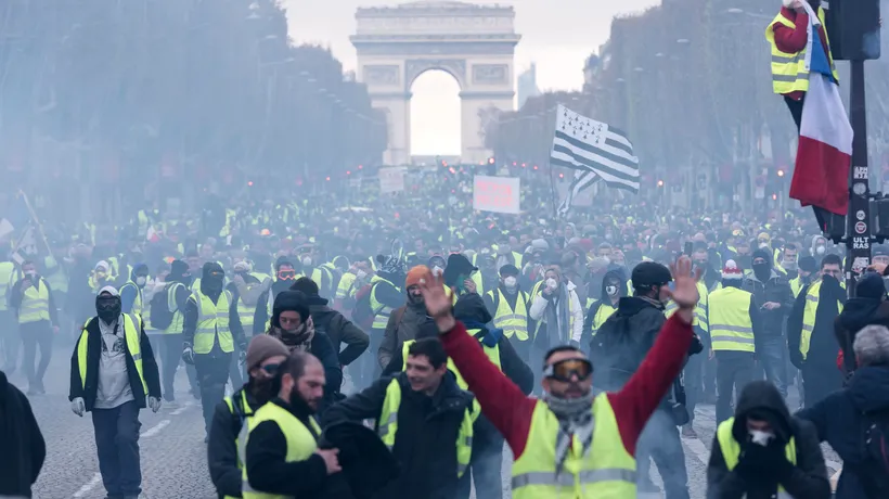 HAOS în centrul Parisului: PIETRE aruncate spre forțele de ordine, mașini INCENDIATE, GAZE lacrimogene și peste 100 de manifestanți REȚINUȚI