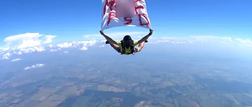 Mesajul M..EPSD coboară din cer. Un parașutist a sărit de la mii de metri cu un banner anti-PSD. Saltul, realizat ÎN AFARA României