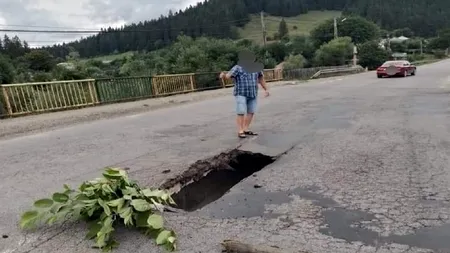 FOTO | Gaură imensă în miljocul asfaltului pe un pod din Neamț. Trafic restricționat pentru camioane