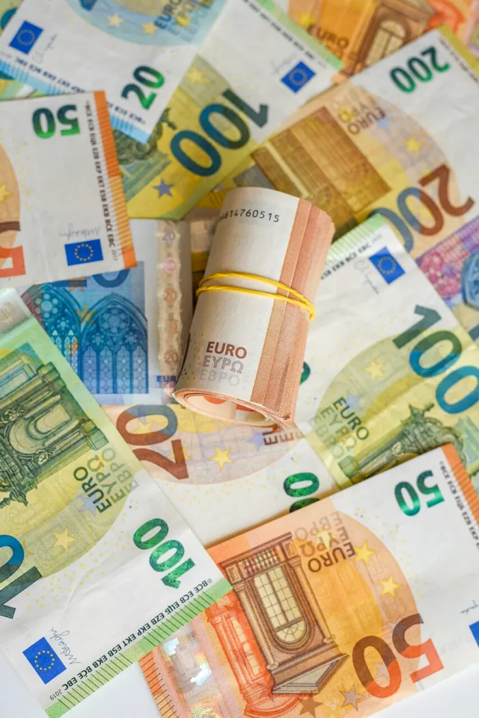 Euros currency spread out across a world map background, illustrating international economic significance