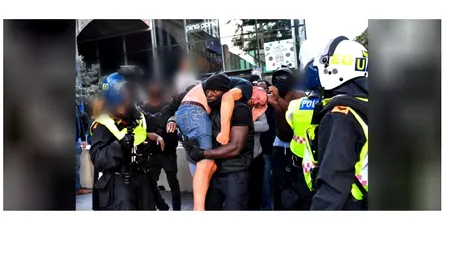 PROTESTE. Un bărbat de culoare, surprins în timp ce salvează un protestatar alb