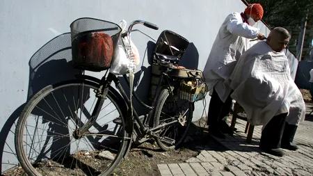 Un frizer din China practică o metodă străveche de tuns, cu clești încinși în foc