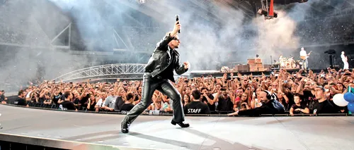 Bono, alergat de un grup de anarhiști, pe o stradă dintr-un oraș german