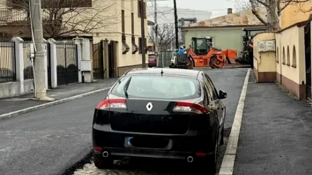 Cum au asfaltat muncitorii din CRAIOVA o stradă pe lângă o mașină parcată. „Am sunat şi la ridicări, dar și ei au întârziat”