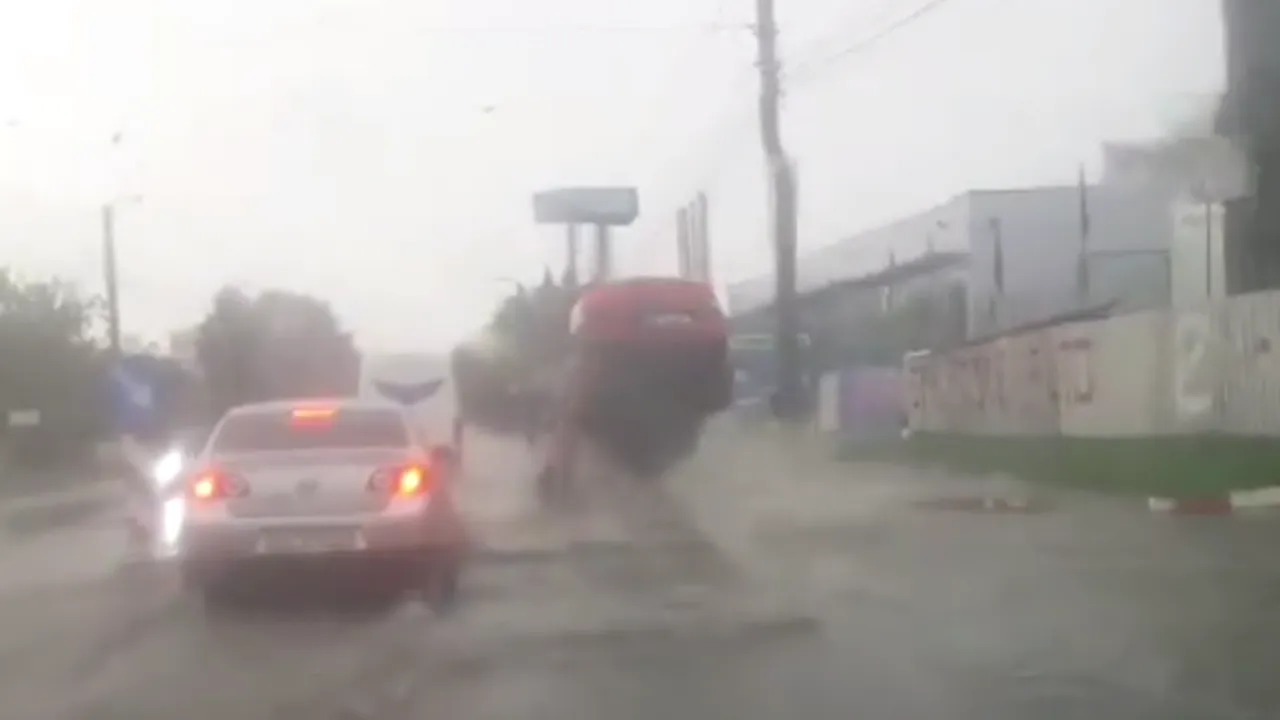 O mașină, propulsată în aer când trece peste o gură de canal